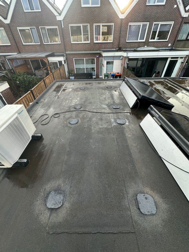 Plat dak met airco-unit en zonnepanelen.