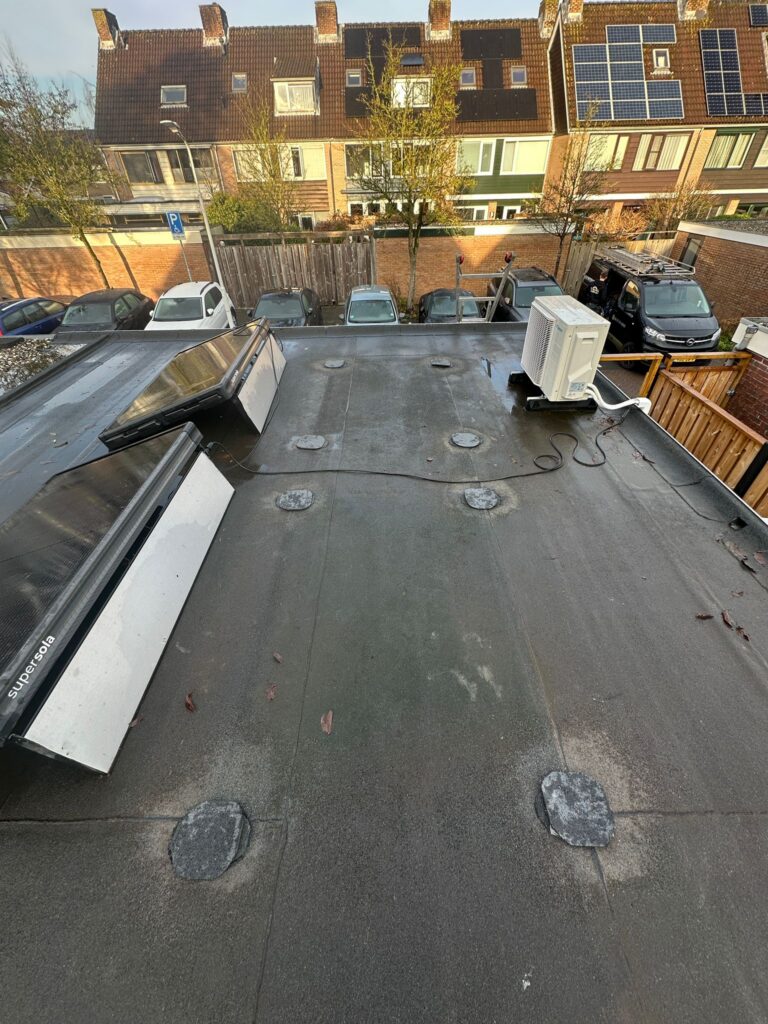 Plat dak met zonnepanelen en airconditioningunit