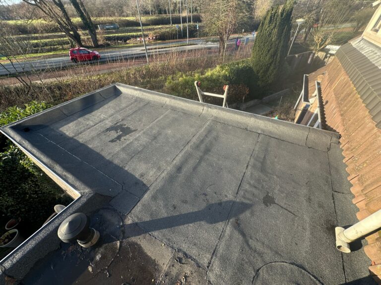 Plat dak in zonnige woonwijk, met uitzicht op weg.