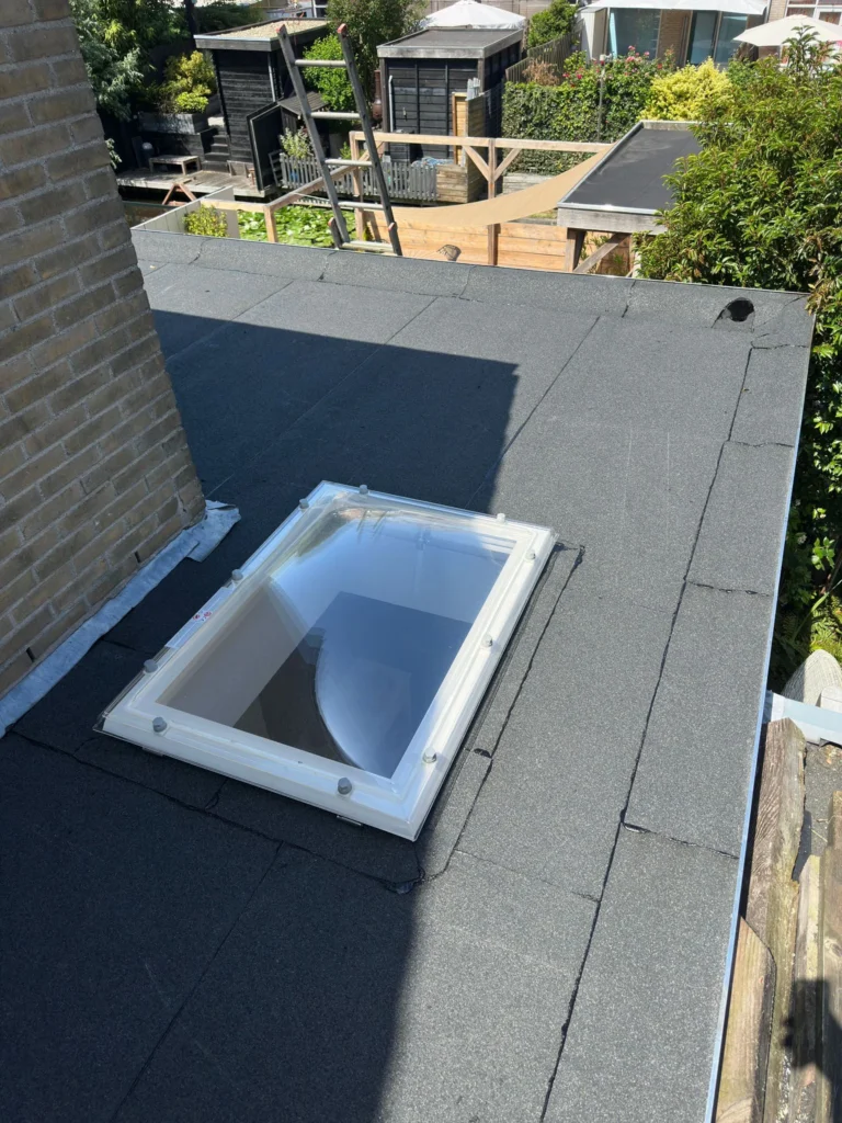 Lichtkoepel in een nieuw plat dak met bitumen dakbedekking in Westzaan